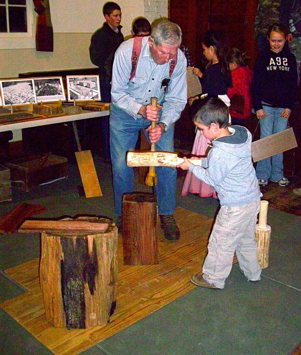 Amboy: Bob Zumstein shows a youngster how to split cedar shakes.