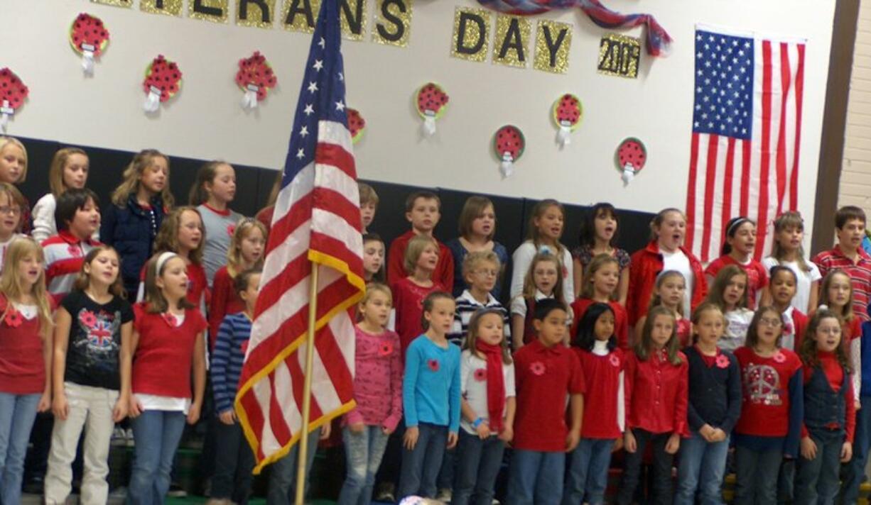 Camas: Students at Lacamas Heights Elementary School celebrate Veterans Day by wearing poppies, singing songs and hosting veterans during an assembly.