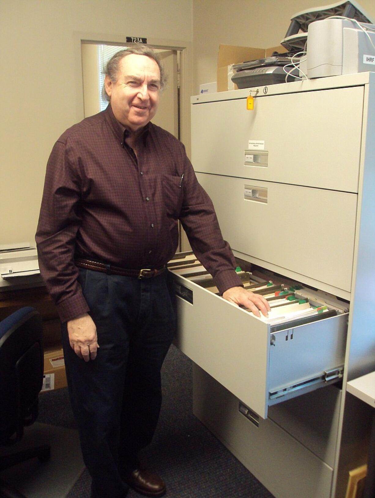 Emanuel Tanne shows off the records of the Intracranial Hypertension Research Foundation.