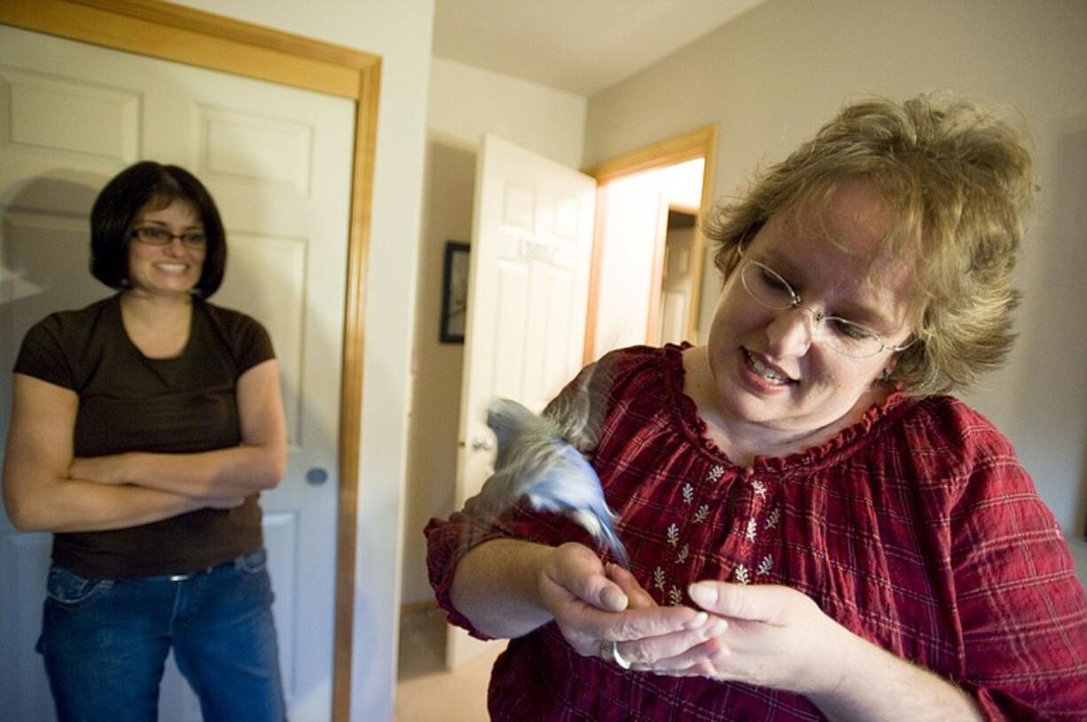 Christa Kangas, right, has learned to read a bird's body language to know when it is in the mood to interact.