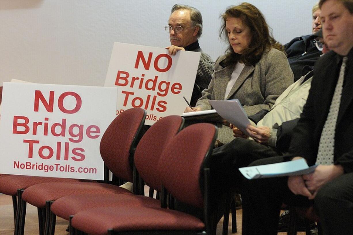 Several anti-toll protesters sat with their signs during a Vancouver City Council session on the proposed Columbia River Crossing project.