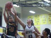 Cherita Daugherty of Prairie High School tries to score as Emma Fisk of Columbia River tries to thwart her attempt at a basketball game in Vancouver Tuesday.