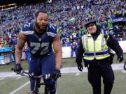 Seattle's Michael Bennett borrows a police officers bike for a celebration lap around CenturyLink Field after winning the NFC Championship game against the Green Bay Packers.