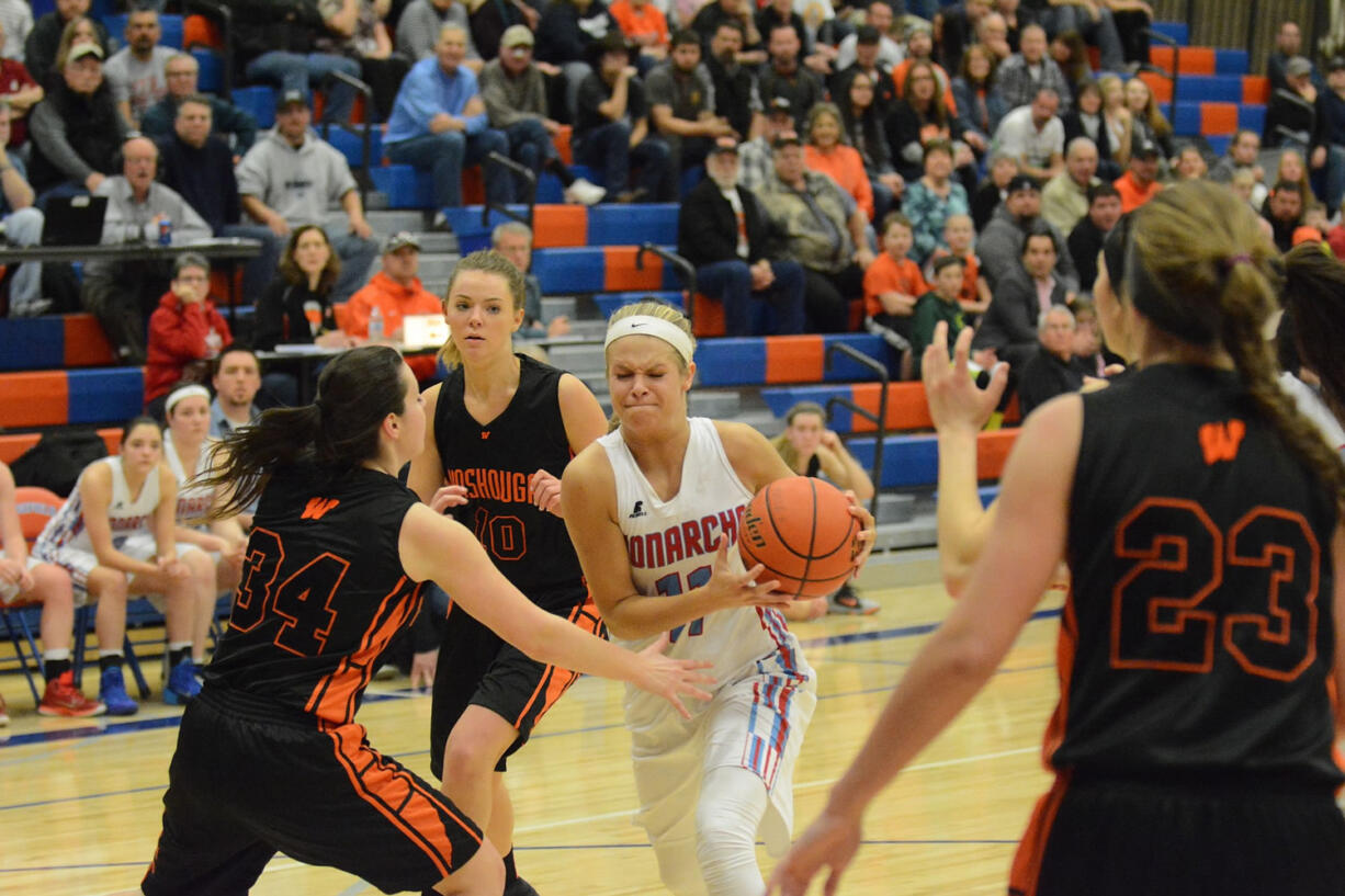 Ashley Coons of Mark Morris drives against Washougal's Alyssa Blankenship, left, during Monday's 2A district girls basketball game at Ridgefield.