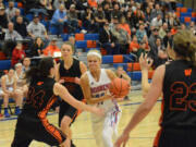 Ashley Coons of Mark Morris drives against Washougal's Alyssa Blankenship, left, during Monday's 2A district girls basketball game at Ridgefield.