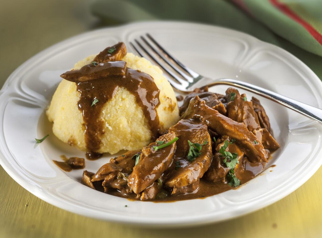 Shredded chicken is simmered in a quick mole sauce, then served with polenta.