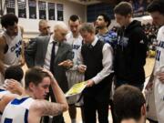 The Clark College men's basketball team huddles during a timeout against Lower Columbia College on Feb.