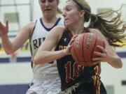 Lindsay Asplund of Prairie High School holds the ball as Megan Bloom of Coulmbia River looms behind her at a basketball game  in Vancouver Tuesday January 13, 2015.