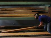 Nick Leidenfrost places wood on a drying rack in January at Goebel &amp; Co. Furniture in St.