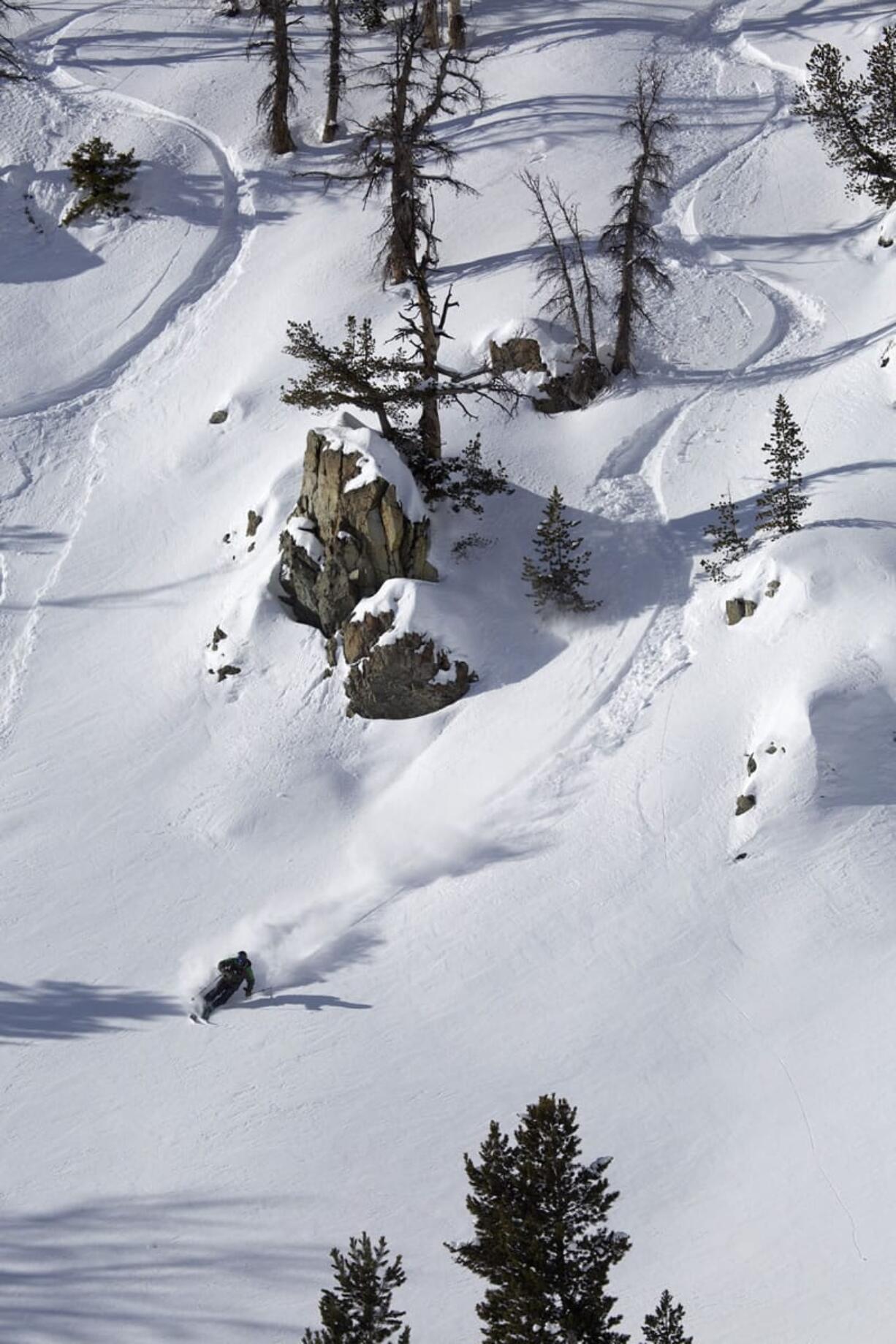 Skiers whoosh down the east ridge of Little Goat Mountain.