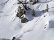 Skiers whoosh down the east ridge of Little Goat Mountain.