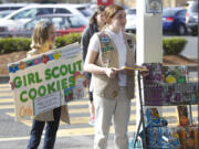 Amy Rapp, left, and Maddy Surface, members of Girl Scout Troop 42561, sell boxes of Girl Scout Cookies on Sunday outside the Fred Meyer in Salmon Creek. Rapp has sold about 150 cookies so far this season, while Surface has sold nearly 900.