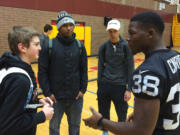 Oakland Raiders cornerback T.J. Carrie talks to Prairie High School students Dante Heithschmidt (left), Adam Ayala (Raiders hat) and Rashaan Bohanan on Tuesday.