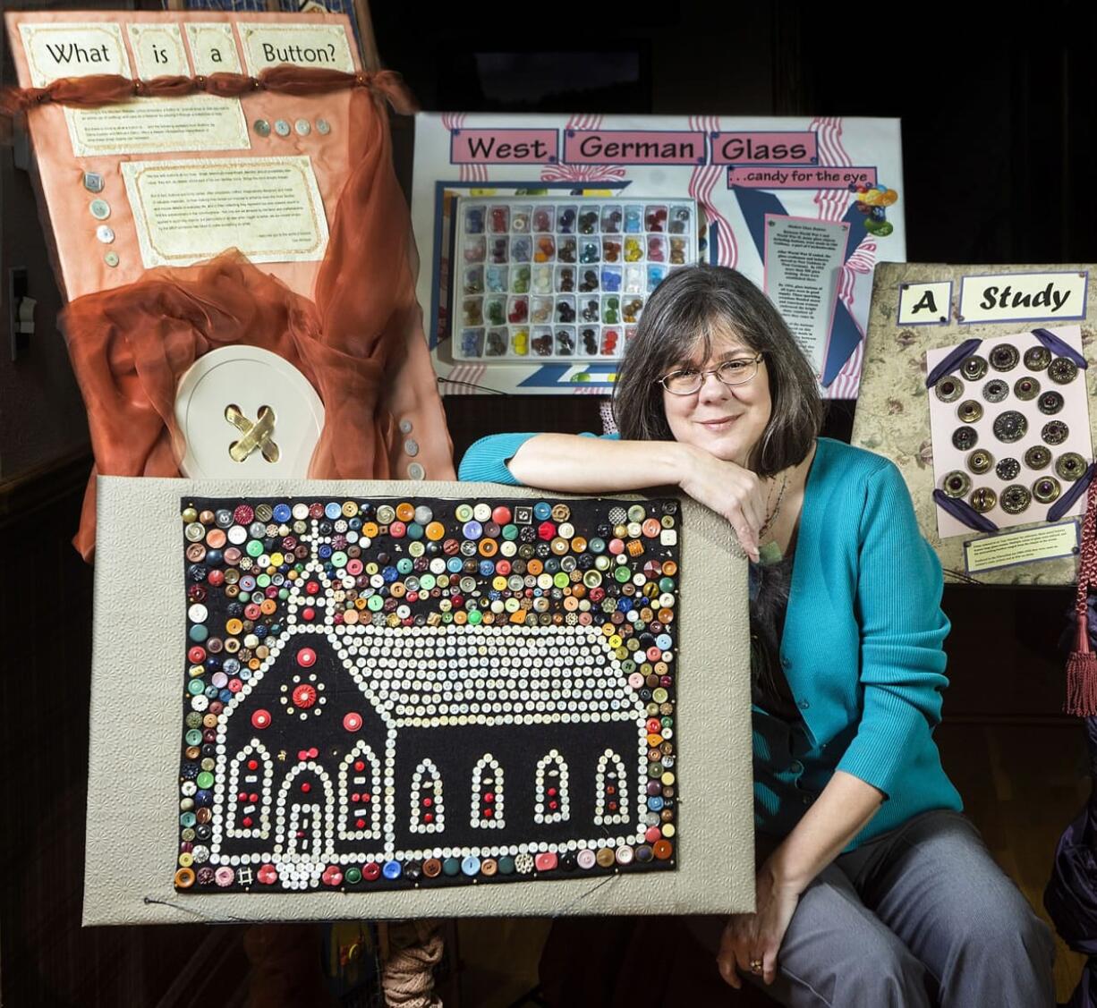 Lise McIntyre is surrounded by some of the buttons she uses in her Traveling Button Museum, including the first collection -- the church design piece -- she purchased more than 20 years ago.