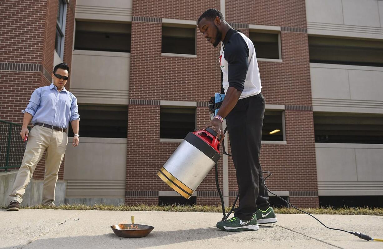 Ricky Carioti/Washington Post
Electrical engineering students Viet Tran, left, and Seth Robertson demonstrate extinguishing a fire with sound waves March 19 at George Mason University in Fairfax, Va.