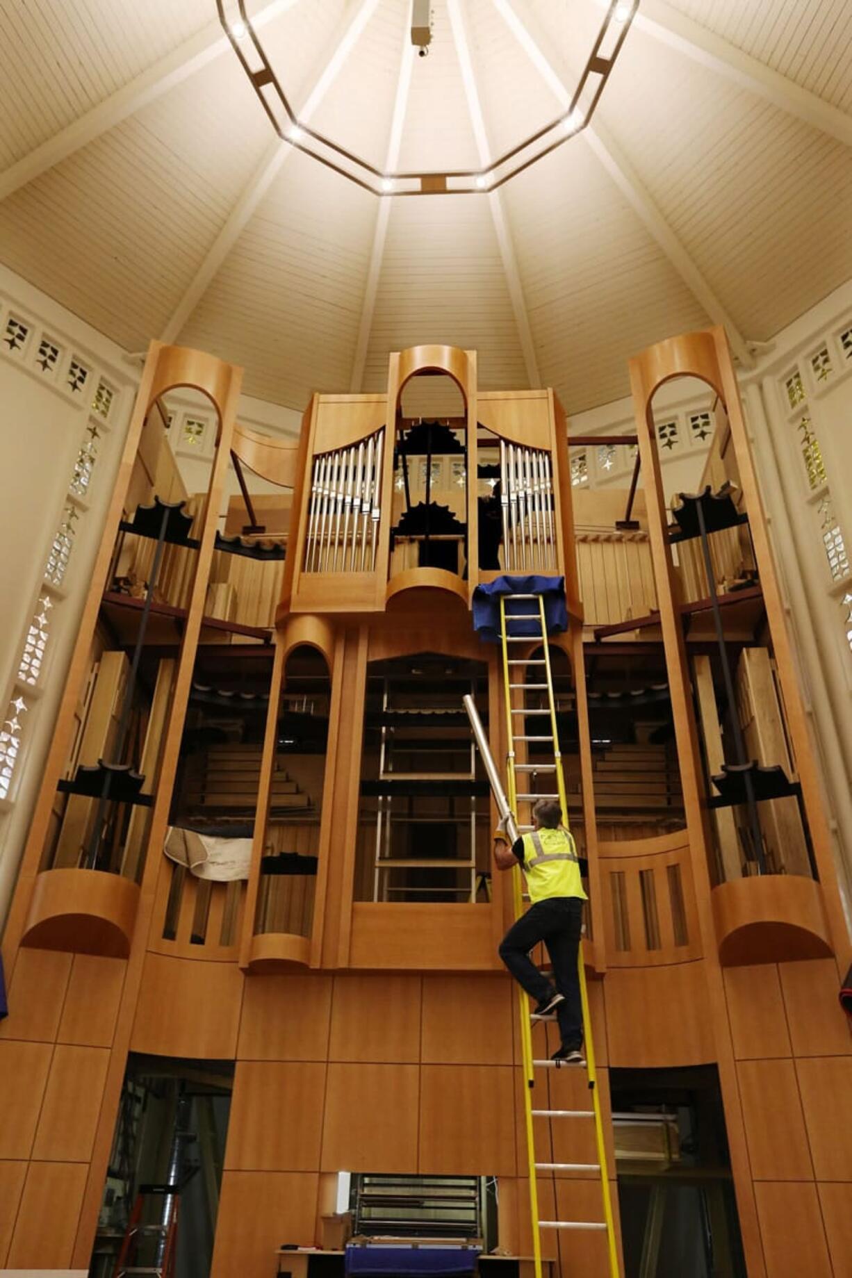 Greg Bover, project manager, carries one of the organ's 3,500 pipes up for placement in Plymouth Church's new $2.4 million organ.