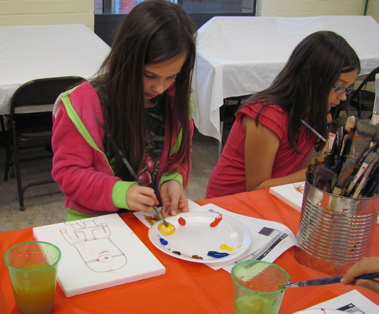 From left, Alyssa Dawson and Kelsey Osmus paint their one-eyed minions during Art Van Go class.