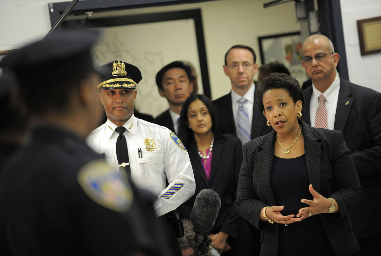 Lloyd fox/Baltimore Sun/TNS
U.S. Attorney General Loretta Lynch, right, speaks with Baltimore Police Commissioner Anthony Batts, left, and other officers at the Central District on Tuesday.