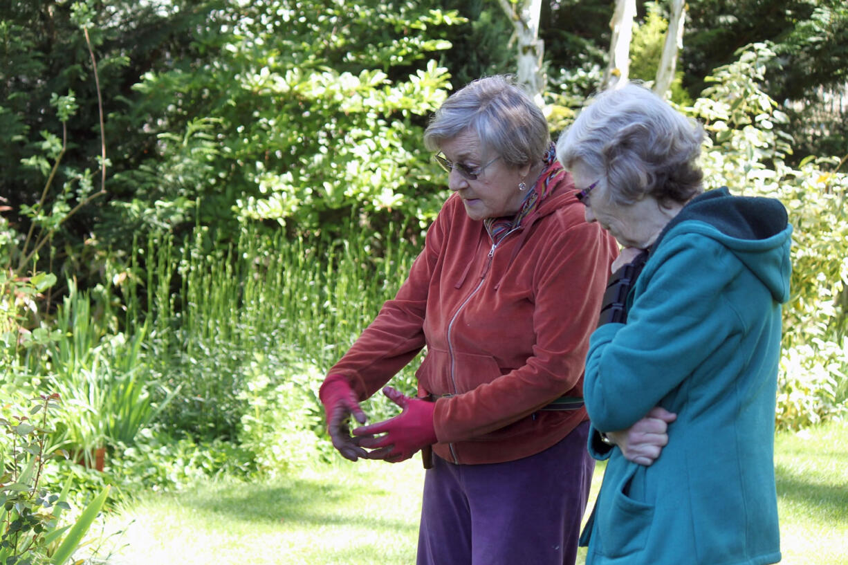 Lilla Larsen (left) talks about the plants and flowers in her yard with Alma Ladd (right), chairwoman of the Two Rivers Heritage Museum's annual plant fairs. Larsen, 70, has provided donations from her garden to support the fundraiser for several years. The Two Rivers Heritage Museum is hosting a plant fair from 11 a.m. to 3 p.m. Sunday.