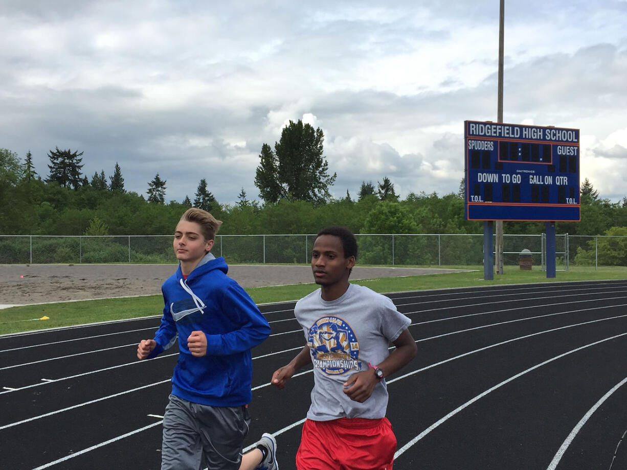 Ridgefield sophomore Silas Griffith, right, runs with teammate Ciarnin McNeil during a recent track practice.