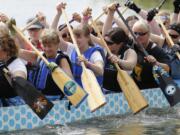 Dragon boat race participants paddle into position for race start at the 2014 Paddle for Life dragon boat festival at Vancouver Lake.