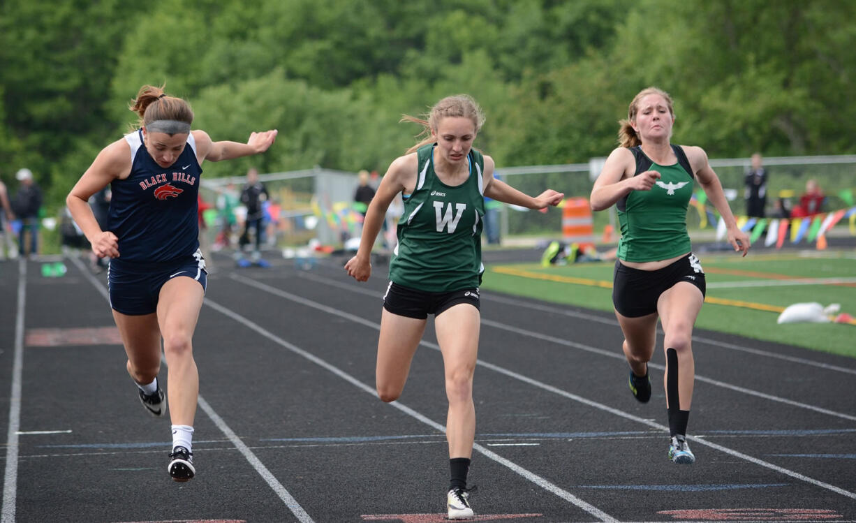 Woodland sophomore Julia Stepper leans at the finish line to win the 100 meters Friday at the Class 2A District 4 Track and Field Championships in Ridgefield.