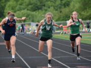 Woodland sophomore Julia Stepper leans at the finish line to win the 100 meters Friday at the Class 2A District 4 Track and Field Championships in Ridgefield.