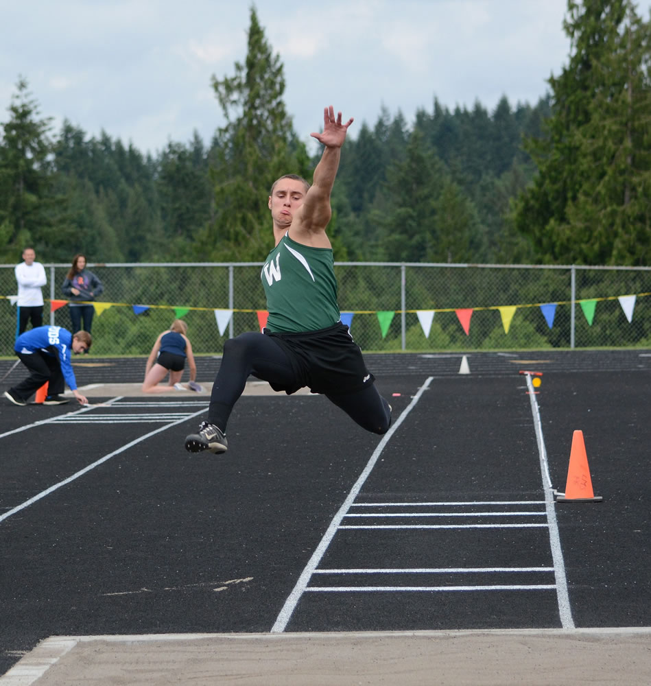 Woodland's Eli Whitmire competes in the triple jump Friday at the Class 2A District 4 Track and Field Championships in Ridgefield. The senior won with a leap of 43 feet, 1 inch.