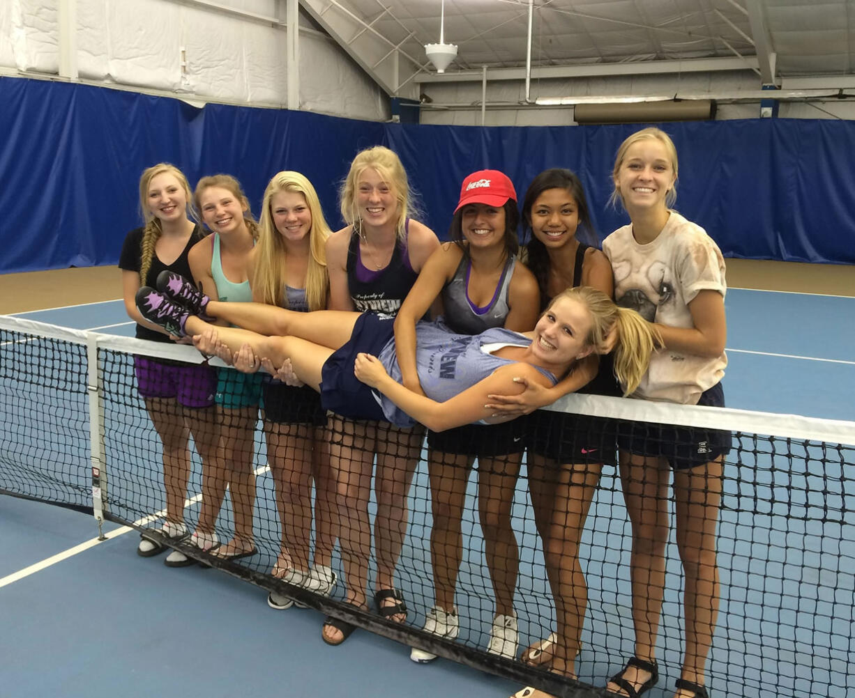 Skyview teammates hold up senior Sammi Hampton on the net on Saturday at the Columbia Basin Racquet Club in Richland after Hampton was declared the Class 4A singles champion for a fourth year in a row.