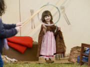 Brigade encampment re-enactor Katie McKenzie of Battle Ground, plays with a Jacob's ladder toy as others play the game of Graces with a hoop and stick at the Fort Vancouver National Historic Site in 2011.