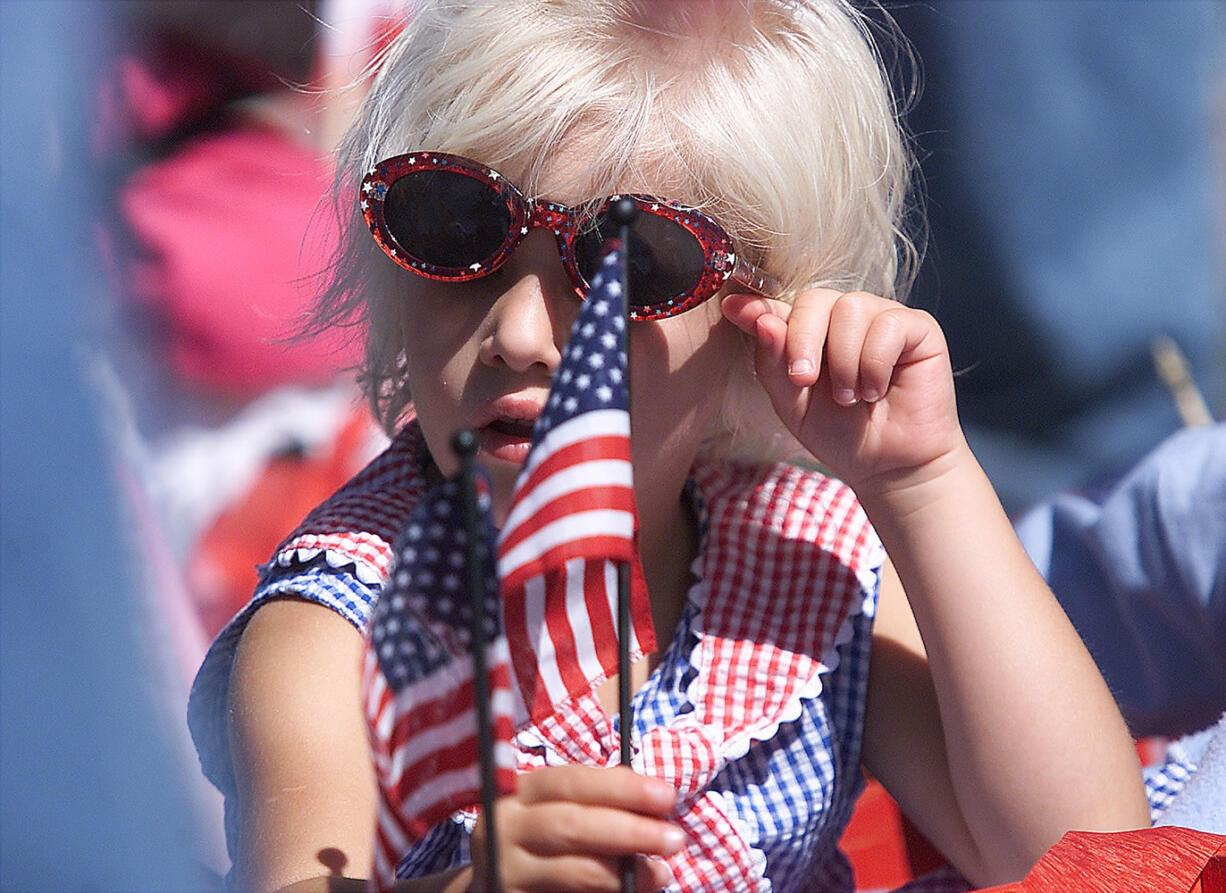 Wearing red, white and blue and waving a small American flag, Cassandra Knobeloch prepares for the July 4th Felida Children's Parade in 2003.