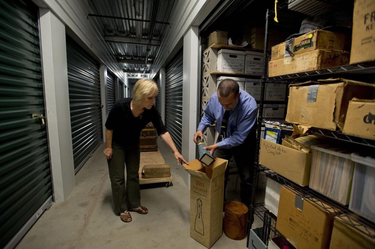 Professional organizer Claudia Smith helps Alan Miller sort through, organize and pare down a storage unit that contains memorabilia once owned by his parents in Davis, Calif.