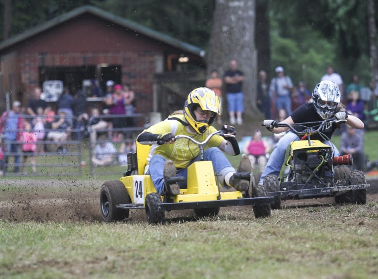 Brenda Olstad vies for the lead as she comes around a bend in the Amboy Territorial days annual lawnmower races in Amboy, Sunday July 13, 2014. Olstad's husband made the lawnmower that she races on.