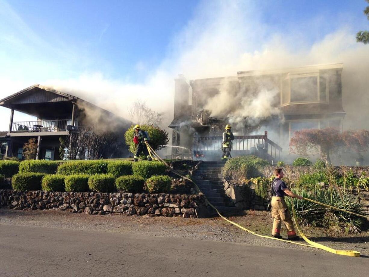 Above, firefighters douse two house fires in Vancouver's Old Evergreen Highway neighborhood on Wednesday evening.