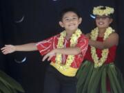 Children perform traditional Hawaiian dances at the Hou2019ike and Hawaiian Festival in downtown Vancouveru2019s Esther Short Park Saturday.