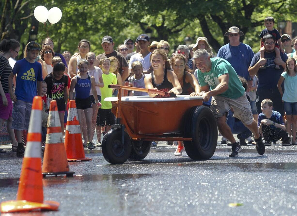 The Ware family weave through traffic cones Saturday as they race in the Camas Days bathtub races in downtown Camas.