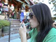 Amanda Gloudeman smokes a pipe with marijuana Saturday night at Mint Tea on Main Street in Vancouver.