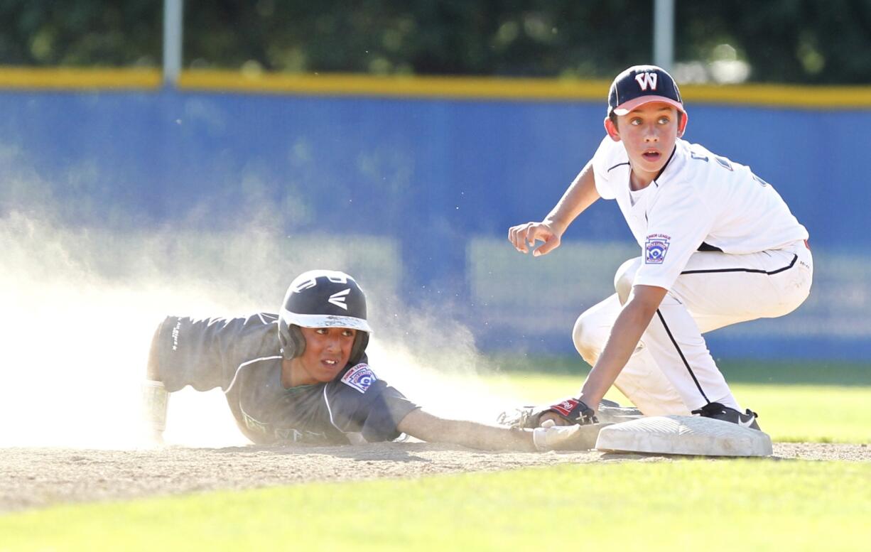 Alex Orr of host team East County (right) tags out a West Salem runner in the Little League Junior Boys Western Region tournament.  West Salem won 11-1 on Tuesday. The tournament continues through Aug.