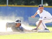 Alex Orr of host team East County (right) tags out a West Salem runner in the Little League Junior Boys Western Region tournament.  West Salem won 11-1 on Tuesday. The tournament continues through Aug.