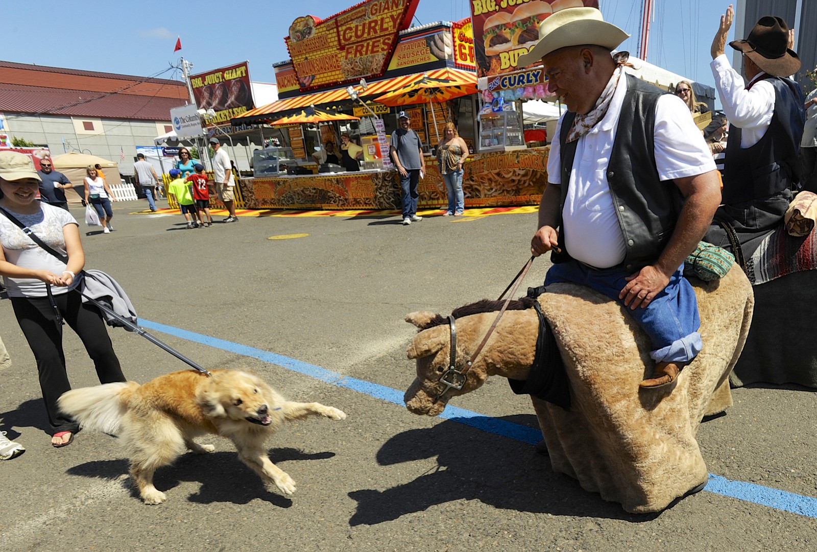 Fairgoer Mochi, held by Caroline Bruce, left, decides it's time to play with Nohawk on Mohawk, right, at the Clark County Fair in Ridgefield on Saturday.