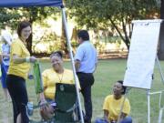 Justin Runquist/The Columbian
Heather England, left, Brandi Williams, center, and Connie Wellman, right, celebrate National Night Out on Tuesday at Water Works Park in Vancouver. The women worked with several neighborhood associations to organize the event, which encourages community members and police to work together in crime prevention.