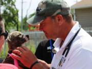 Lake Zurich Veterinarian Jack MacKenzie meets a young patient waiting in line at a free pit bull health clinic hosted by the Bryan