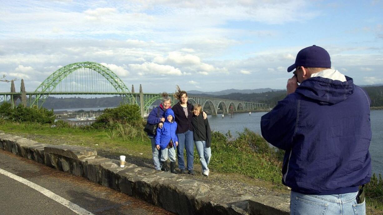 Visitors to Newport, Ore., use the historic Yaquina Bay Bridge as a backdrop for a family portrait.