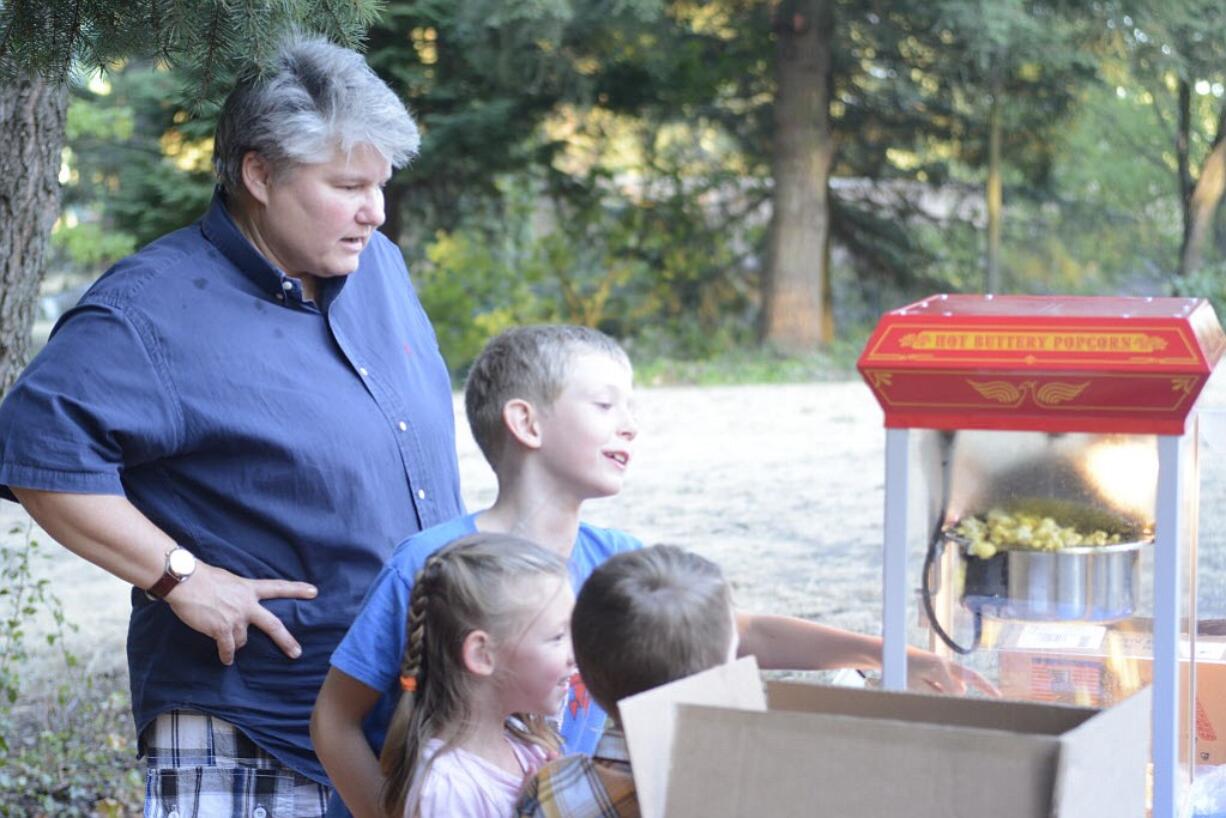 Colleen Neel makes popcorn for a crowd that gathered at Water Works Park to watch &quot;The LEGO Movie&quot; on Friday.