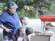 Colleen Neel makes popcorn for a crowd that gathered at Water Works Park to watch &quot;The LEGO Movie&quot; on Friday.