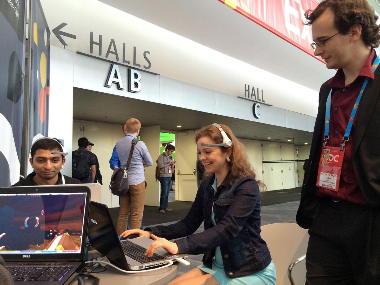 Lat Ware, right, watches Natalia Veselova playing his game, &quot;Throw Trucks With Your Mind,&quot; in March at the Game Developers Conference in San Francisco.