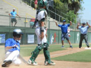 Cascade Little League third base coach Brendan McCarthy begins to celebrate the game tying run, scored by Mason Hill (left), as third base umpire George Rodriguez calls Hill out after McCarthy was called for aiding the runner ending the game. A coach is not allowed to touch a player while the ball is still in play. Cascade lost to Idaho 8-7 on Friday, August 14, 2015 ending their season at the Little League Northwest Regionals in San Bernardino, Calif.