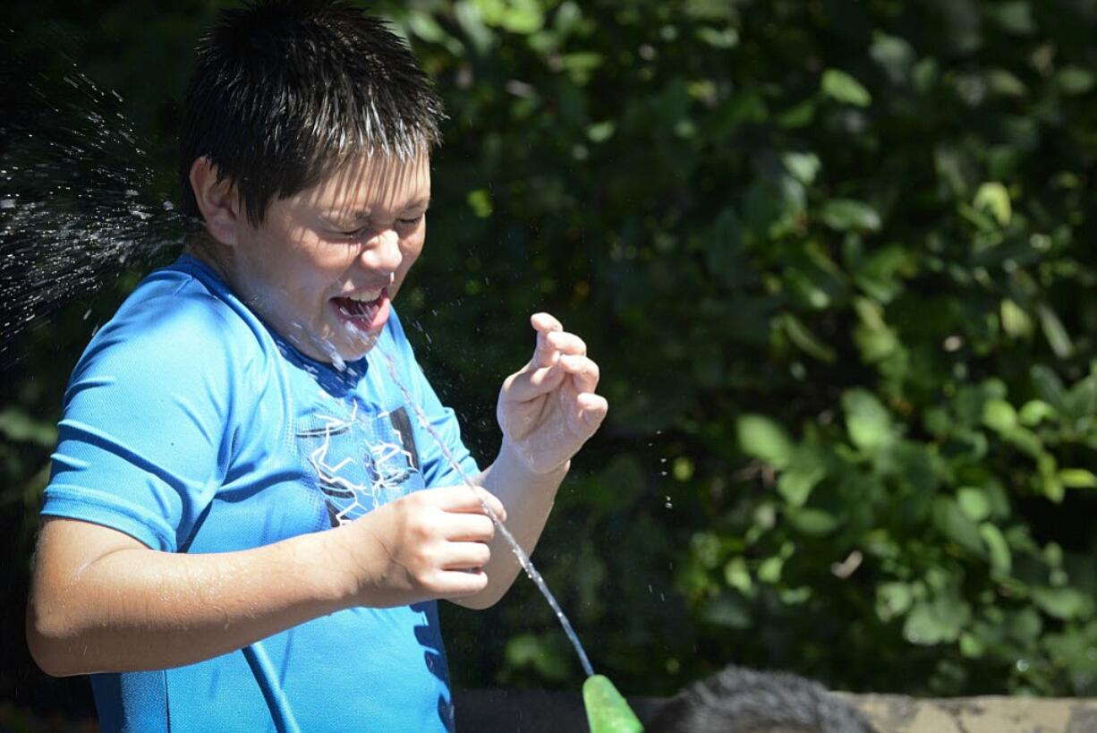 Ariane Kunze/The Columbian files
Carlos Fuerte, 10, gets a surprise spray in the face at the Esther Short Park fountain on a 101-degree day in July. This summer may break a record for days with high temperatures exceeding 90 degrees, but unlike Portland, our record streak is longer.