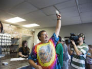 Associated Press files
Mike Boyd turns to the crowd outside, showing off the 4 grams of marijuana he bought as the first in line to legally purchase marijuana at Spokane Green Leaf on July 8, 2014.