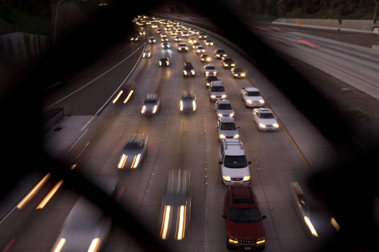 FILE - In this Nov. 22, 2011 file photo, cars travel on a freeway in San Diego. During the long 2014 holiday weekend, 46.3 million Americans are expected to go 50 miles or more from home, the highest number since 2007, according to travel agency and car lobbying group AAA. That would be a 4.2 percent increase over last year.